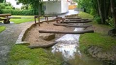 Flußlauf mit Balance-Holzstämme, Wegeinfassung